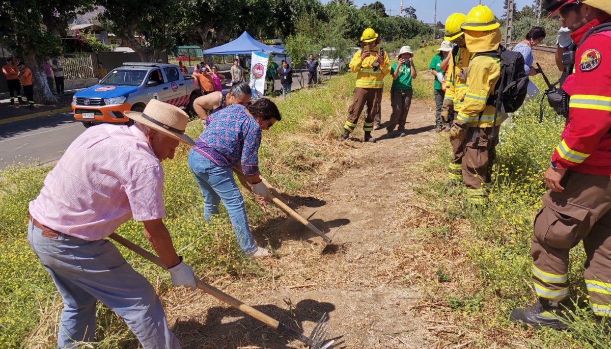 Brigadistas de Conaf instruyeron a los residentes de San Pedro en Quillota sobre cómo construir cortafuegos.